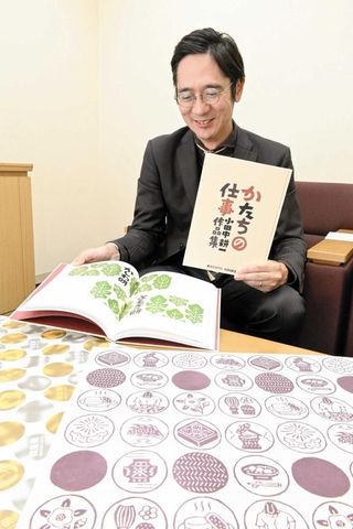 小田中耕一さんの作品集を紹介する山田宗平社長＝姫路市阿保甲