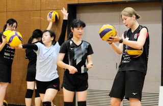 ヴィクトリーナ姫路の麻野七奈未選手（右端）からサーブの打ち方を学ぶ姫路聴覚特別支援学校生＝姫路市本町