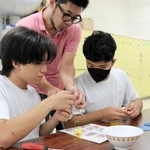 松森栄次さん（中央）に教わりながら、革の端材で動物のキーホルダーを作る生徒ら＝姫路特別支援学校