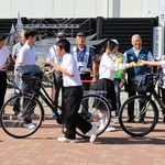 自転車で登校する生徒に、ヘルメット着用などを呼びかけるチラシを配る姫路工業高校生ら＝姫路市伊伝居