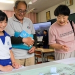 手作りしたすごろくで地域住民と交流する安富北小学校の児童（左）＝姫路市安富町杤原