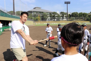 小学生にスイングのこつを教えるＴ－岡田さん＝ウインク球場