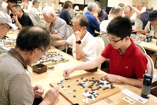 真剣な面持ちで対局に臨む囲碁大会の参加者ら＝播磨国総社、総社会館