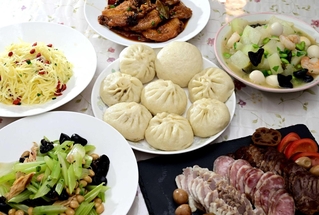 肉包子を中心に（上から時計回りに）手羽の八角風味の煮物、豚のスープで炊いたトウガン、牛すじ煮込みと塩豚と腸詰めが並ぶ前菜、湯葉とセロリの炒め物、千切りジャガイモをネギ油で和えた中国風ポテトサラダ＝姫路市勝原区
