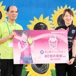 市川町の津田義和町長から委嘱状代わりのパネルを受け取るヴィクトリーナ姫路の桜井美樹選手＝市川町文化センター