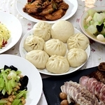 肉包子を中心に（上から時計回りに）手羽の八角風味の煮物、豚のスープで炊いたトウガン、牛すじ煮込みと塩豚と腸詰めが並ぶ前菜、湯葉とセロリの炒め物、千切りジャガイモをネギ油で和えた中国風ポテトサラダ＝姫路市勝原区