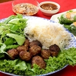 ベトナム・ハノイの名物「ブンチャー」（左手前）は甘酸っぱいタレ（左上）につけて食べる。エビやキュウリなどを巻いた生春巻き（右）は、特製のピーナツソースがぴったり＝姫路市北条