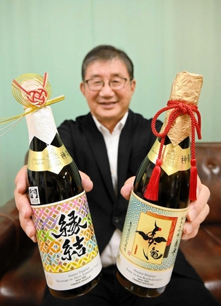 精米歩合４．７％の純米大吟醸「亀の甲　寿亀」（右）と、山田錦を１３．９％まで磨いた「縁結　結寿」をアピールする田中康博社長＝姫路商工会議所