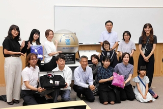 開封されたタイムカプセルの前で記念撮影する１９９９年度の在校生ら＝姫路市大津区天満、姫路南高校