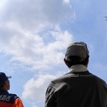 物資搬送のため離陸するドローンを見上げる防災フォーラムの参加者＝青山小学校