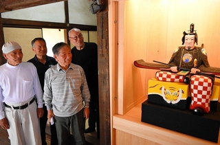 修復を終えた随神像の左大臣を見つめる氏子ら＝姫路市野里、大歳神社