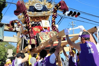 鳥居の前で屋台を差し上げる氏子ら＝土山八幡神社