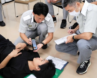 翻訳アプリを活用して症状を聞き取る救急隊員ら＝飾磨消防署
