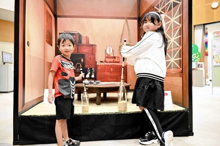 瓶の中の玄米を棒で突いて精米する「米つき」を体験する子どもたち＝姫路市西延末