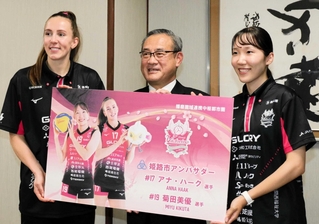 姫路市の岡本裕副市長（中央）から記念パネルを受け取ったヴィクトリーナ姫路のアナ・ハーク選手（左）と菊田美優選手＝同市役所