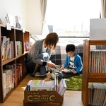 モデルハウスの子ども部屋に並べられた絵本を楽しむ親子＝姫路市延末