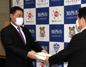西村和平市長（右）に答申を手渡す米田秀志委員長＝加西市役所