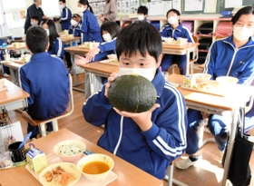 給食を食べる前に特産カボチャ「ダークホース」に見入る児童たち＝九会小学校