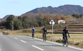 加東市のランドマーク「三草山」を背に国道３７２号を走る自転車愛好家＝加東市上三草