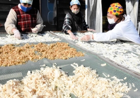 寒い中で切り干し大根作りが続く。切った大根を１枚ずつ広げていく＝地域活動支援センター「庵ノ上」