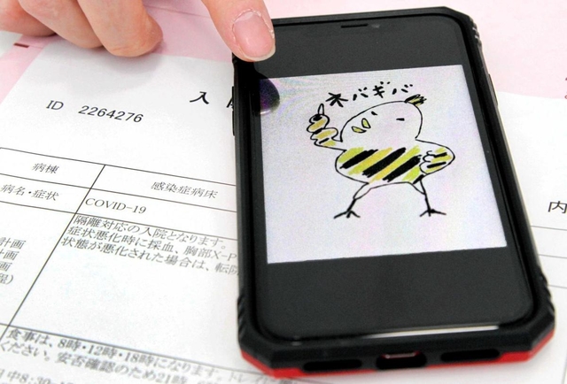 新型コロナウイルスへの感染を示す病院の書類と、入院中、同僚から送られた励ましの絵を見せる男性職員＝多可町内