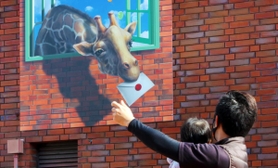 キリンがくわえた手紙を渡す？　思わず手を出す人の姿も＝加東市下滝野