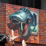 壁面から恐竜が飛び出すように見える看板のだまし絵＝加東市下滝野