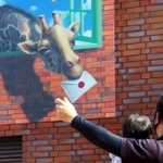キリンがくわえた手紙を渡す？　思わず手を出す人の姿も＝加東市下滝野