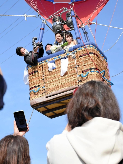 ブーケトスをする菅野祐貴さん、祥加さん夫妻＝いこいの村はりま