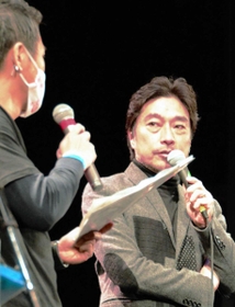 ステージ上であいさつするトータス松本さん＝西脇市郷瀬町、西脇民会館