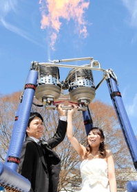 共同作業として「愛のバーナー」で炎を上げる菅野祐貴さん、祥加さん夫妻＝いこいの村はりま