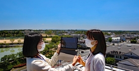 加東市の特徴の一つ、広い空の下、タブレットを使い市街地をテスト撮影する市職員＝加東市社から