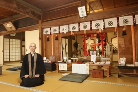 森見生副住職と本地堂。神仏習合の神道独特の祭祀を見ることができる＝加東市栄枝