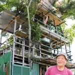 ツリーハウス風の小屋と西村義孝さん＝加西市