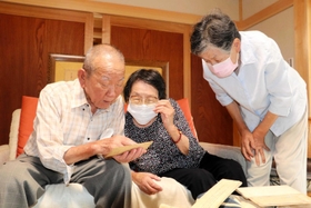 当時の資料を見ながら、空襲の記憶を語る（左から）田中靖雄さん、田中妙子さん、田中美恵子さん＝加東市下滝野
