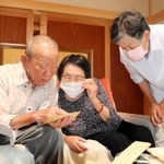 当時の資料を見ながら、空襲の記憶を語る（左から）田中靖雄さん、田中妙子さん、田中美恵子さん＝加東市下滝野