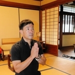 「記事になったことをつゆさんも喜んでいるのでは」。仏壇の前で手を合わせる阿江つゆさんのやしゃご、克彦さん＝加東市