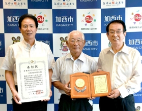 表彰を受けた（左から）社長の西村和平市長と佐伯武彦元副社長、高井均・元総務企画部長＝加西市役所