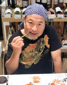 筆を持つ井上稔也さん＝２０１９年６月、神戸市内（家族提供）