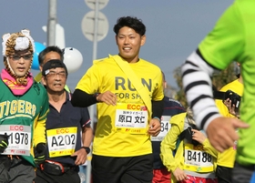 小野ハーフマラソンで沿道の声援に応える阪神タイガースの原口文仁選手（中央）＝２０１９年１２月、小野市内