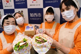 新たに開発された２種類の「鶉野ライスバーガー」とおにぎり工房かさいのメンバーたち＝加西市役所