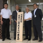 事業所の看板を手にする関係者ら＝加東市社