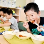 おいしそうに鶏肉をほおばる児童＝多可町中区森本