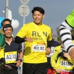 小野ハーフマラソンで沿道の声援に応える阪神タイガースの原口文仁選手（中央）＝２０１９年１２月、小野市内