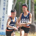 男子・西脇工の２区山中達貴選手（右）が区間新記録を達成し、３区塩田大空選手につなぐ＝西脇市総合市民センター（撮影・笠原次郎）