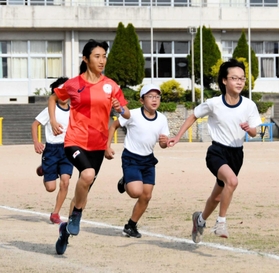 校庭で小学生と走る田中希実選手＝西脇市黒田庄町岡