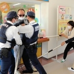 訓練で不審者役を抑え込む小野市立児童館チャイコムの職員と小野署員＝小野市浄谷町