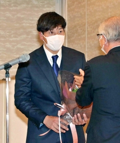 出席者から花束を受け取る翁田大勢投手＝西脇ロイヤルホテル