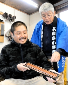 ビャクダンのそろばんを製作した宮永英孝会長（右）と、現社長の信秀さん＝小野市垂井町
