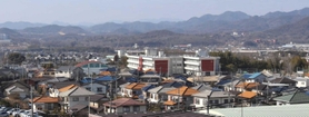 市街地の一角に建つ社小学校（中央の白い建物）。小中一貫校完成後は閉校するため、市中心部に広大な跡地が生まれる＝加東市社